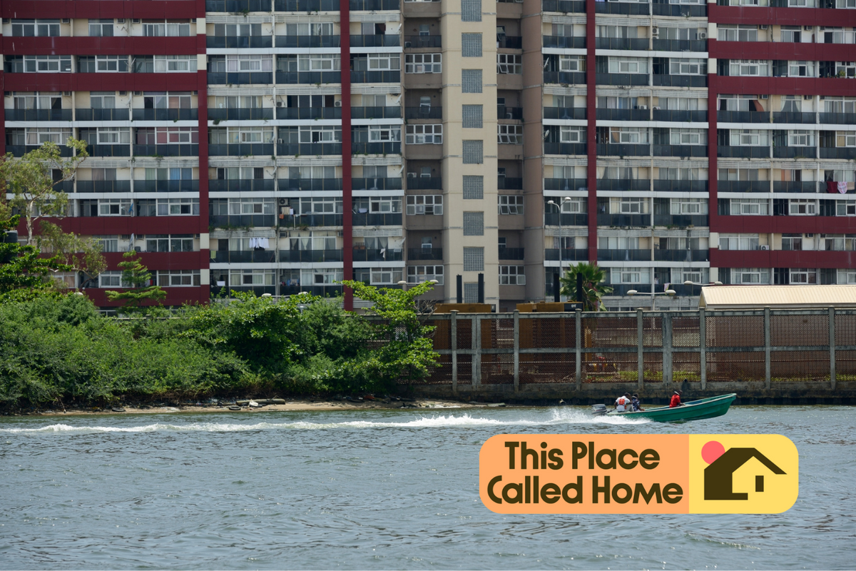 A block of apartments facing a body of water, with a green boat on the water