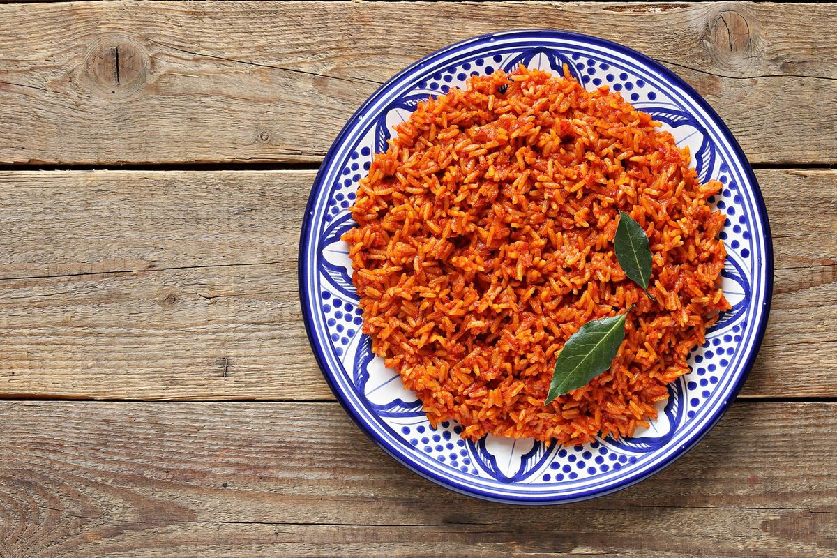 A close up image of a plate of jollof rice on a table. 