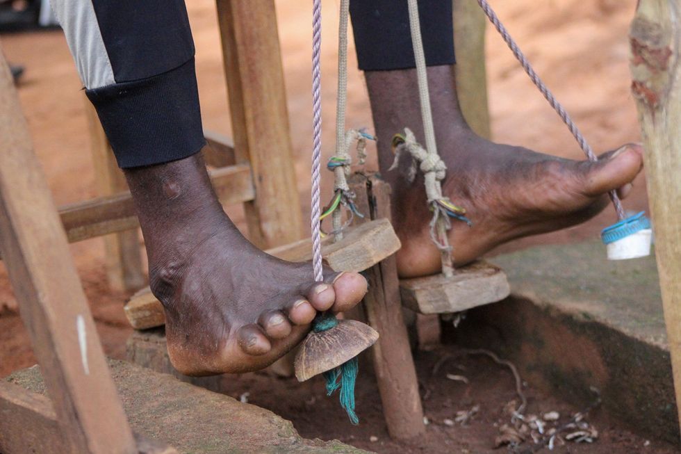 A close up image of feet stretching kente cloth.