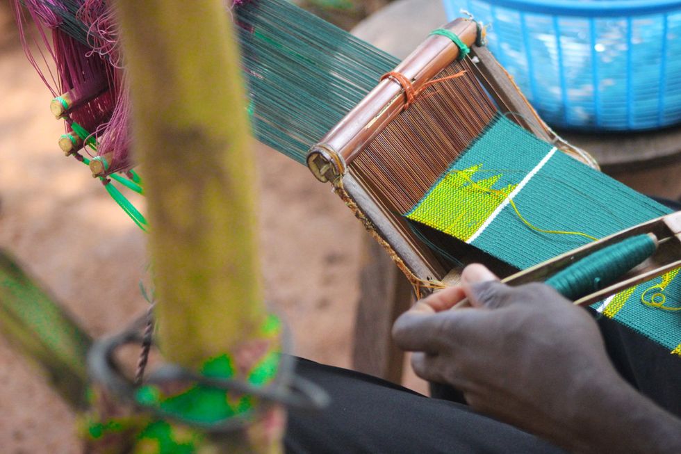 A close up image of kente cloth being tightened.