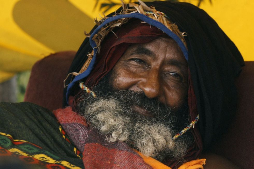 A close-up shot of Eshete, he is smiling and wearing a hooded jacket covering his head.