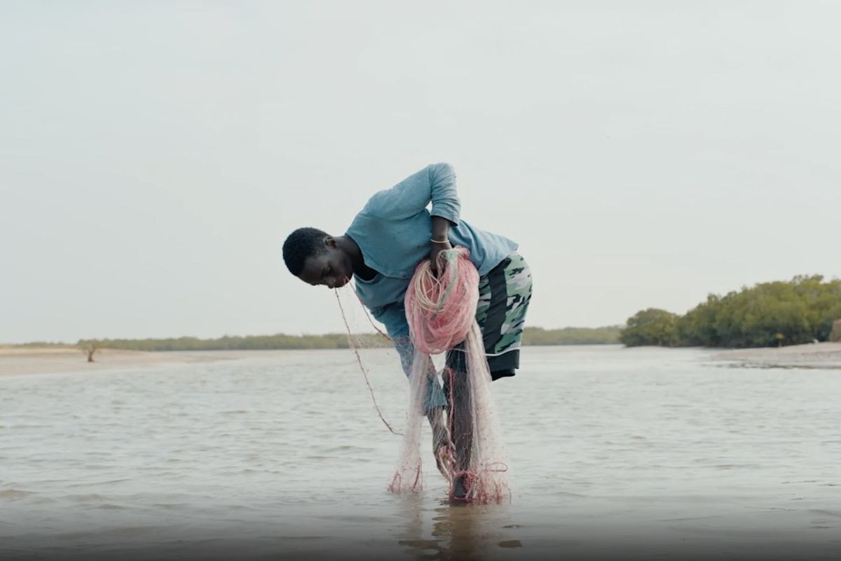 A fisherman gathers his net in a scene from DJ Snake’s music video film Patience.