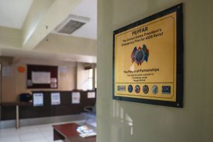 A gold plaque inside a medical facility, with the word “PEPFAR” and underneath it, “The United States President's Emergency Plan for AIDS Relief.”