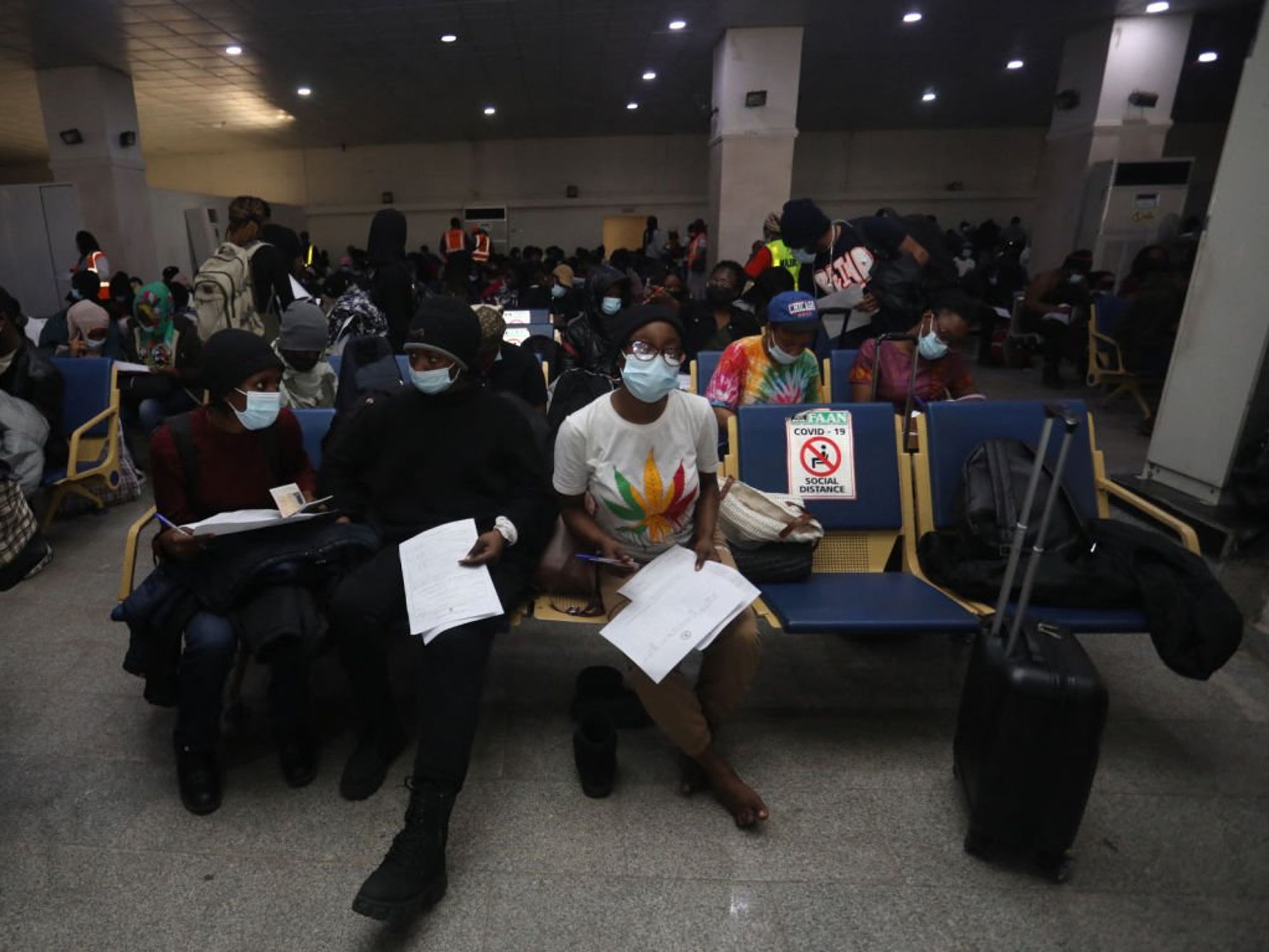 ​A group of Nigerian students fill out their data at Nnamdi Azikiwe airport.