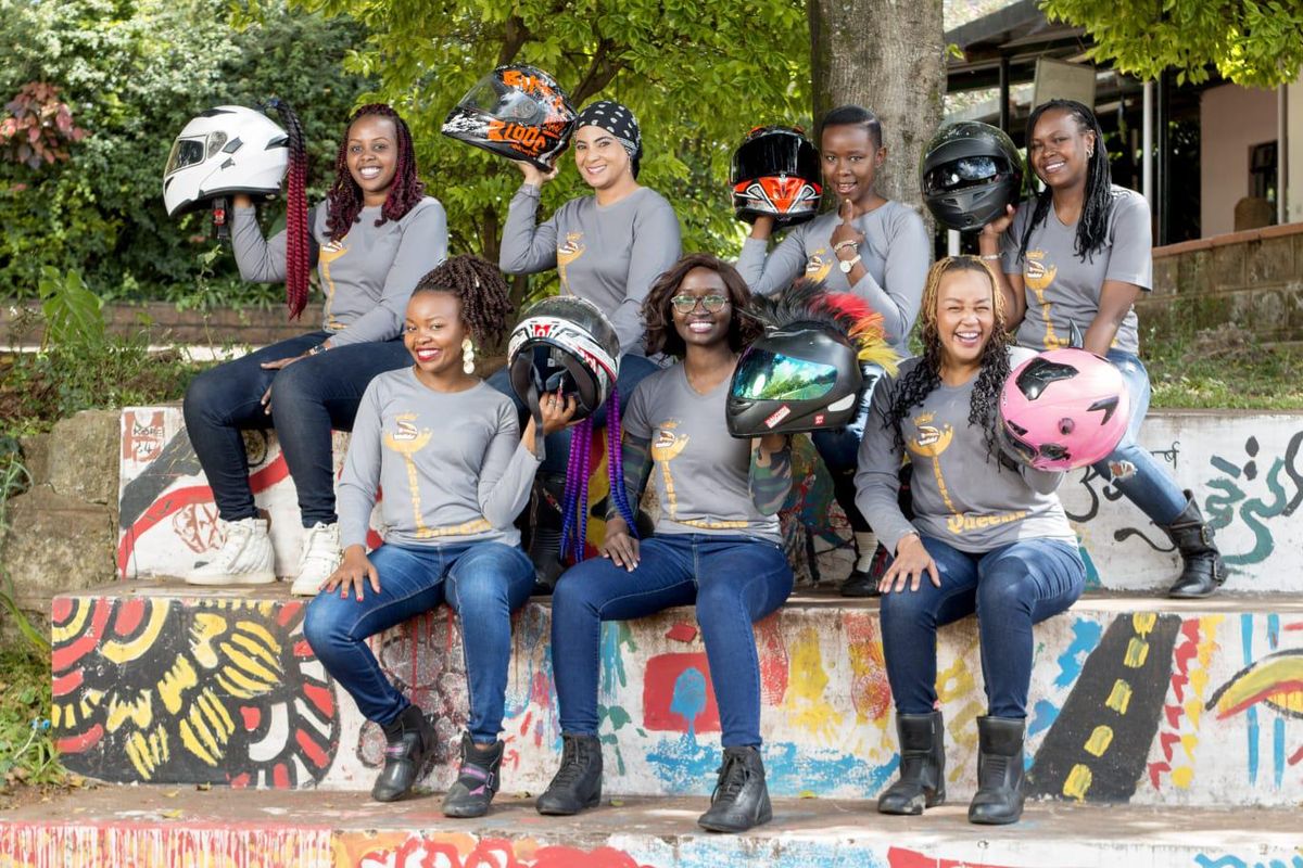 A group of women pose with their motorcycle helmets