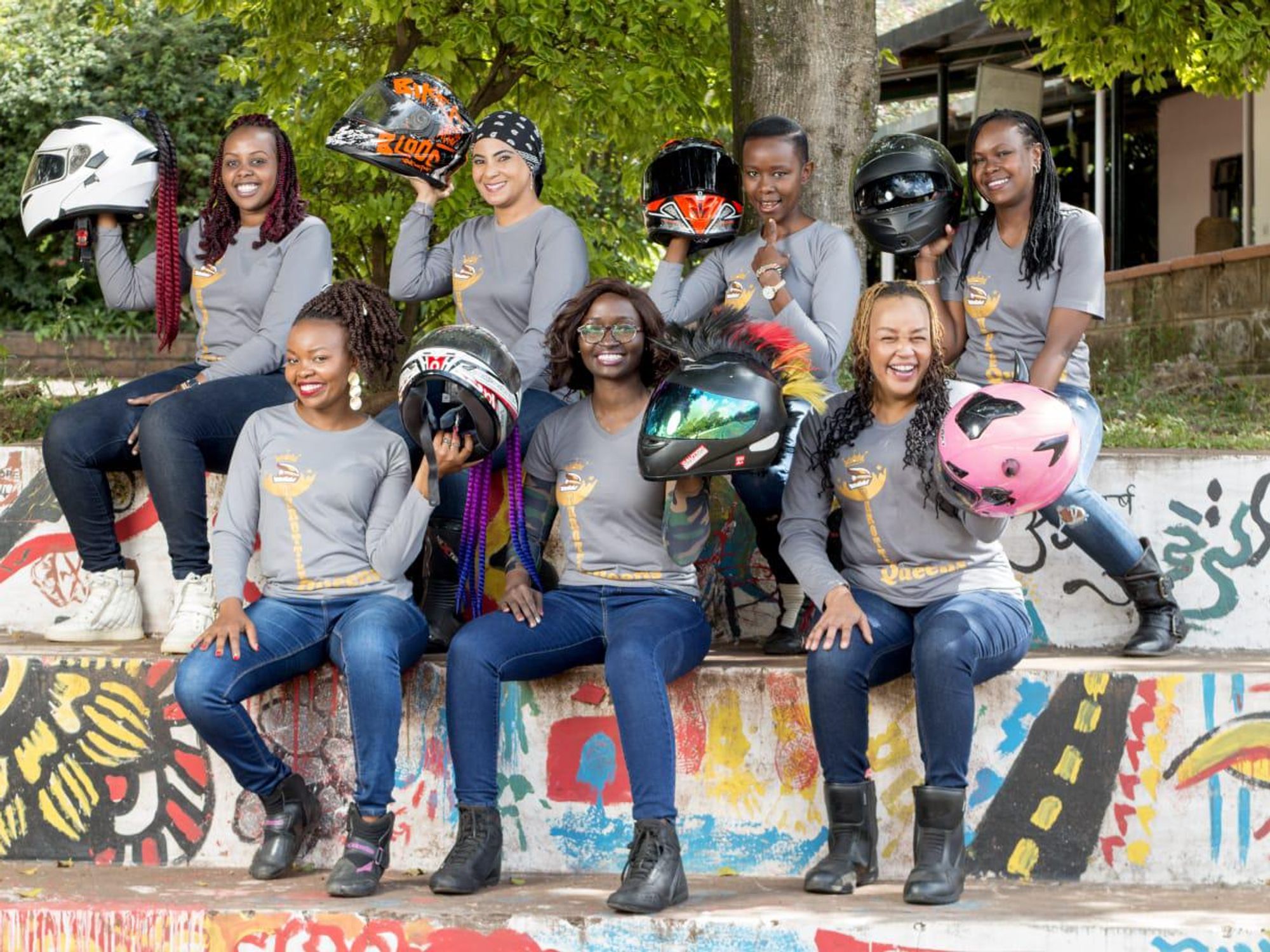 A group of women pose with their motorcycle helmets