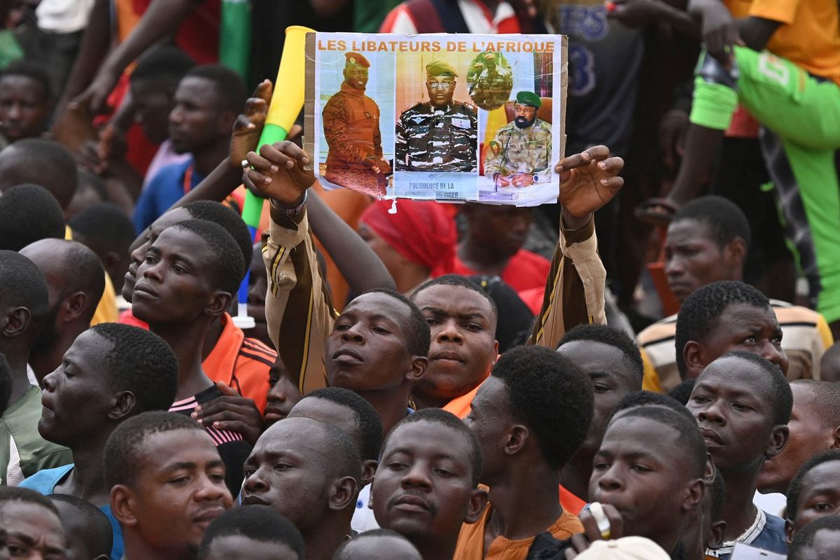 A man holds a placard with the image of Niger's new military ruler General Abdourahamane Tiani on as supporters of Niger's National Council of Safeguard of the Homeland (CNSP) protest outside the Niger and French airbase in Niamey on September 2, 2023 to demand the departure of the French army from Niger.