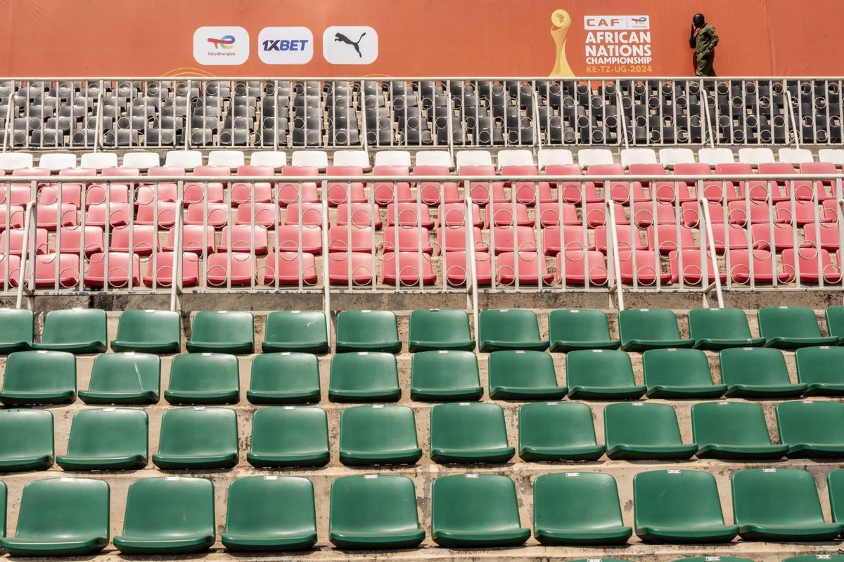 A man walks past rows of empty stadium seats.