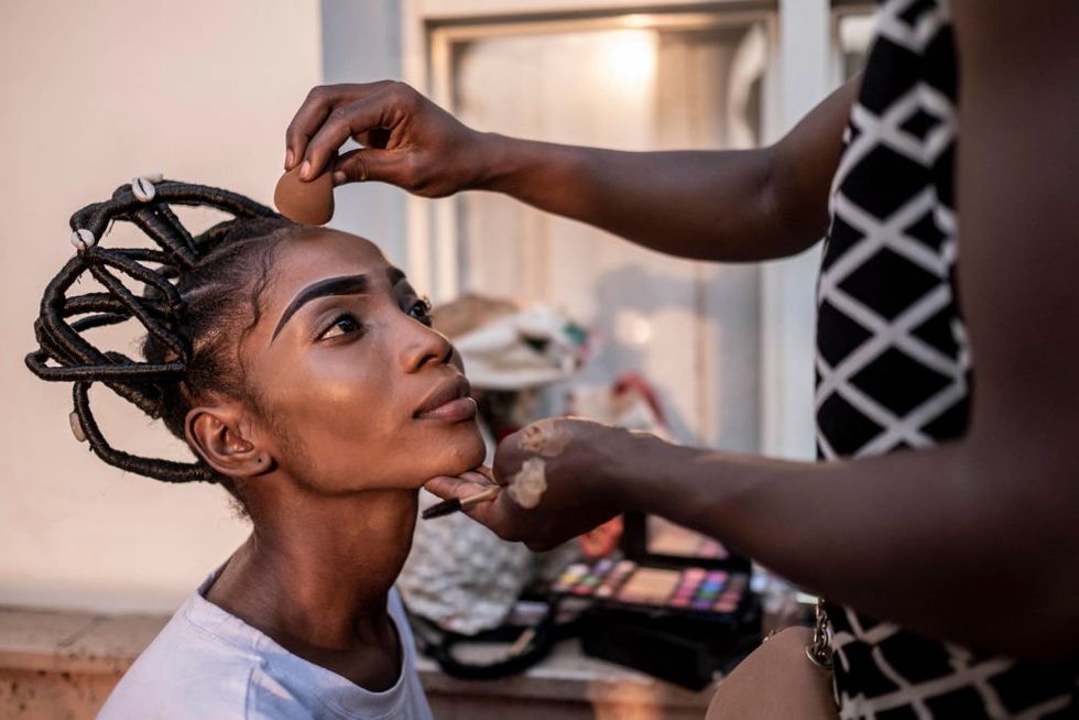 A model gets her make-up done ahead of the first Central African Fashion Week in a makeshift dressing room at the Ledger Hotel in Bangui, December 17, 2022.
