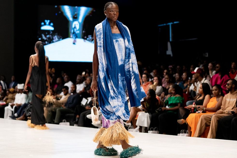 A model on the runway wearing Ekikere at Lagos Fashion Week 2023, a brand known for their hand batik garments and raffia detailing.
