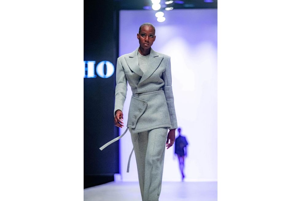 A model wearing a gray trouser suit at the TJ Who show during Lagos Fashion Week 2022.