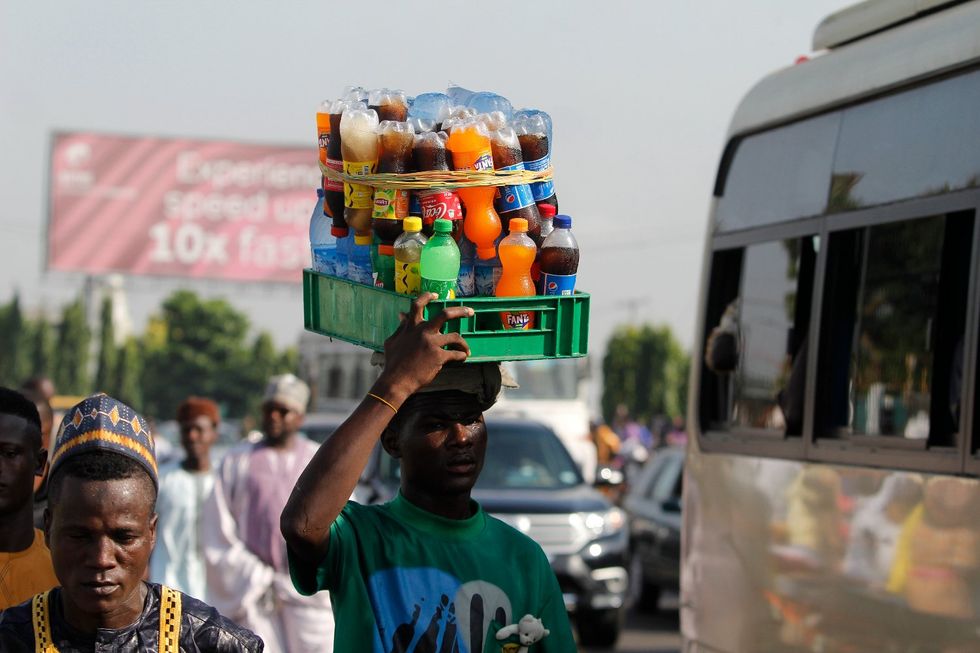 A photo of a man hawking drinks in Lagos, Nigeria.