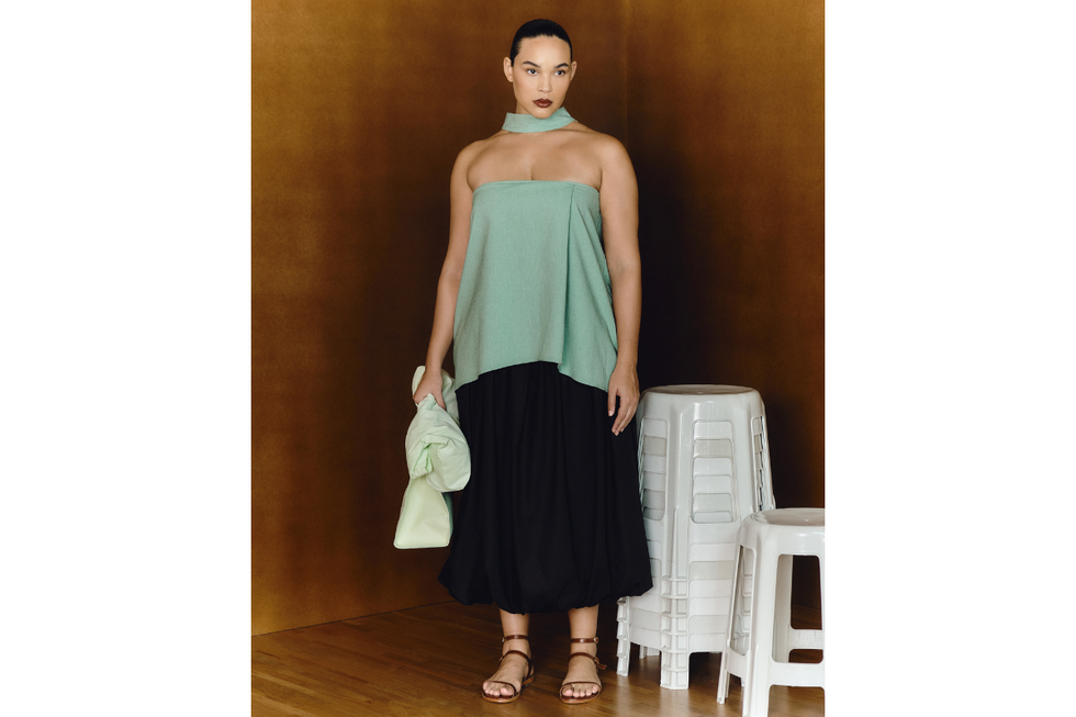 A photo of a model in a light green top and black skirts for Angela Brito\u2019s Pilgrimage collection.