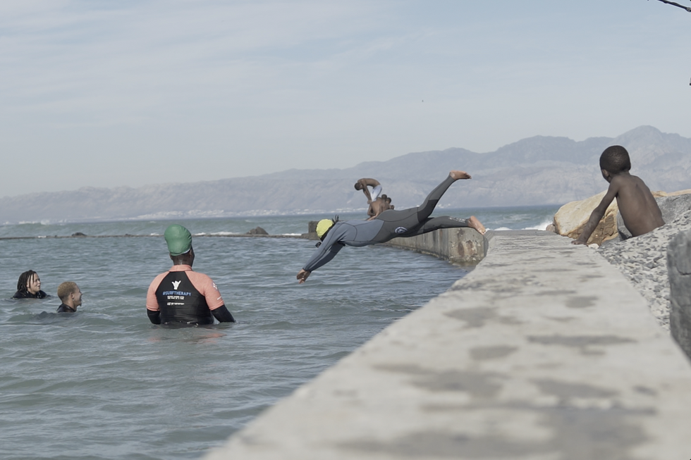 A photo of a person diving into the water in Monwabisi Beach in Cape Town\u2019s Khayelitsha township.