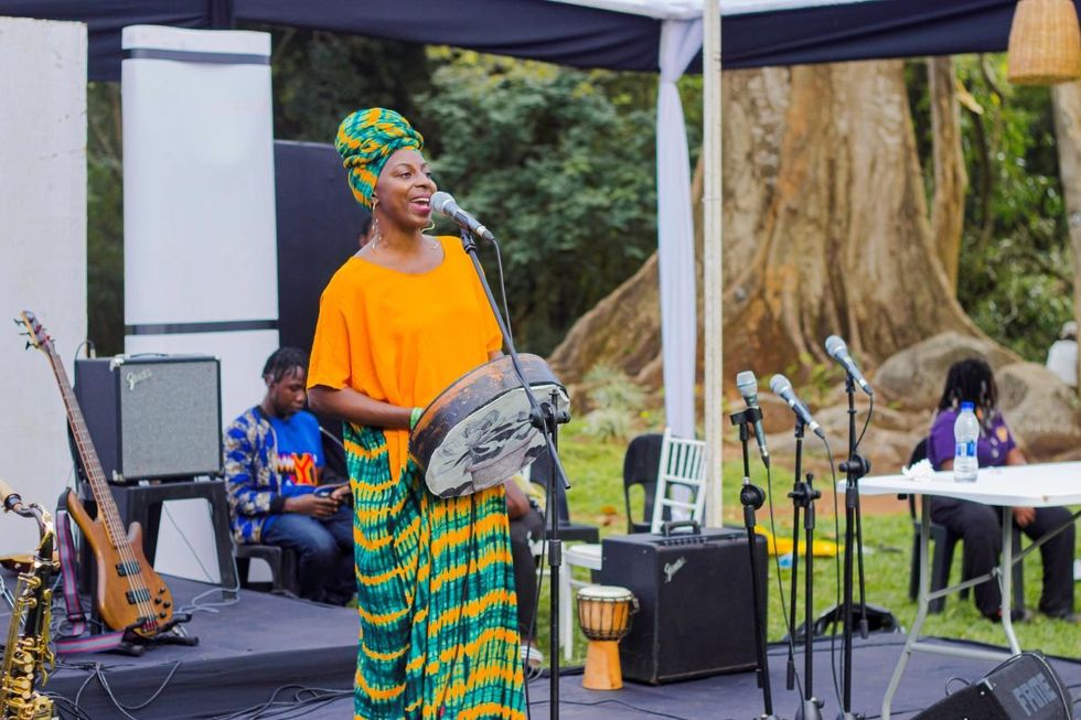 A photo of a woman singing while playing a local music instrument at the Zomba City Festival.