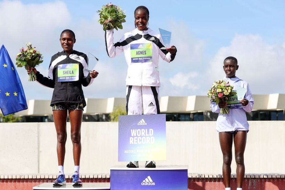 A photo of Agnes Tirop on the gold medal podium after winning the ADIZERO: ROAD TO RECORDS Women's 10km in 30:01 minutes at Adidas HQ in Germany.