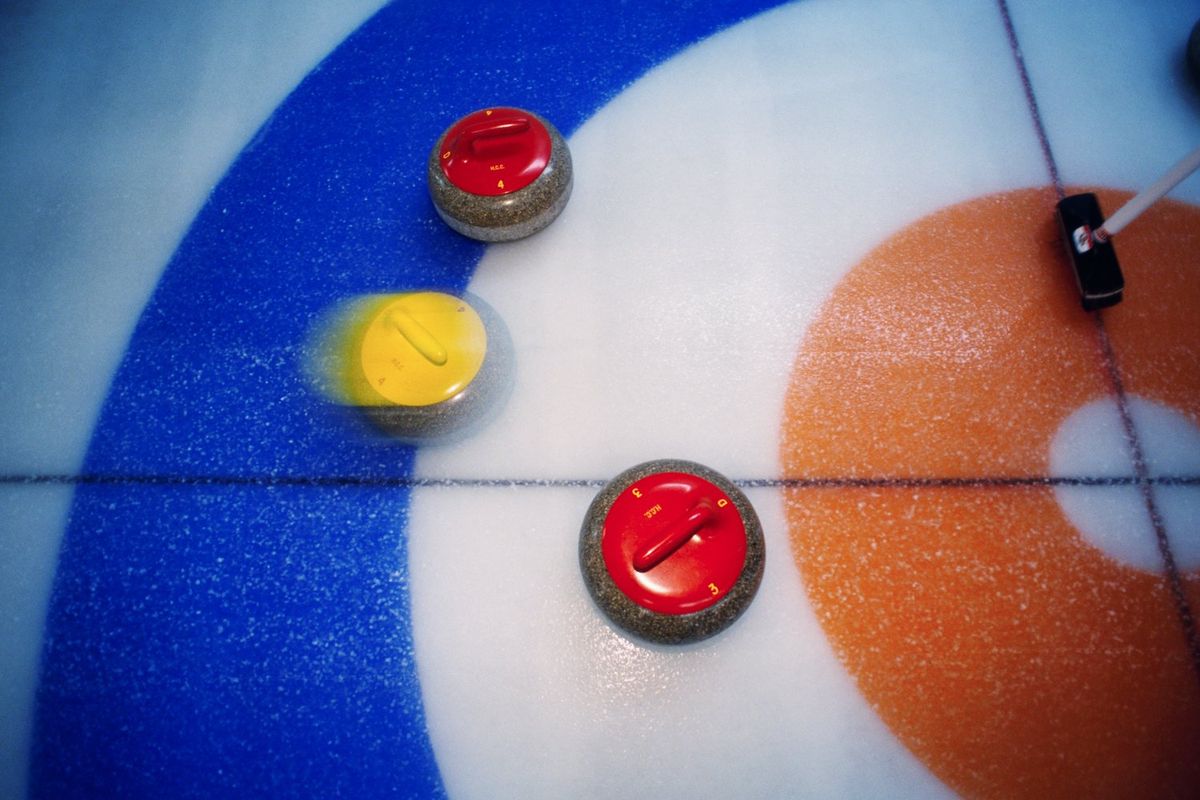 A photo of curling stones moving over the ice.