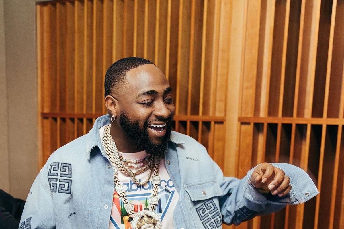A photo of Davido wearing a two-piece denim set and a white t-shirt.