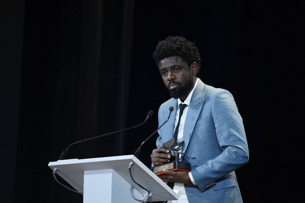 A photo of Joel Kachi Benson holding the Best VR Story Award he received for \u201cDaughters of Chibok\u201d at the 76th Venice Film Festival in 2019.