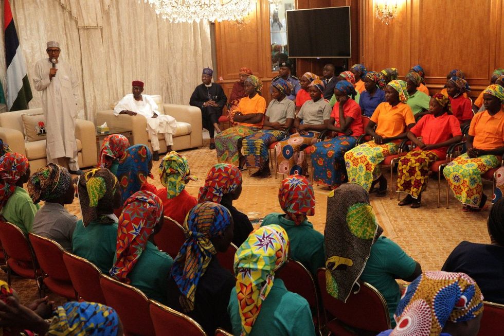 A photo of President of Nigeria Muhammadu Buhari (L) speaking with the 82 Chibok schoolgirls released in May, 2017.