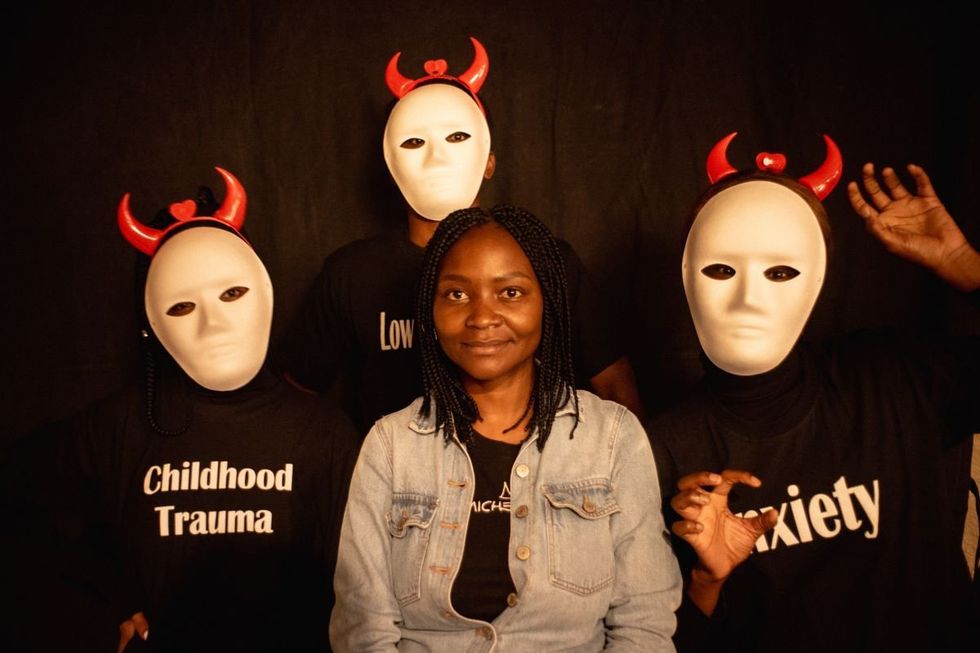 A photo of Sara Chitambo, surrounded by three people wearing masks, with t-shirts that had the inscriptions: anxiety and childhood trauma on two of them.