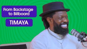 A photo of Timaya wearing a white shirt and black hat and smiling. The words "From backstage to Billboard - Timaya" are written beside him.