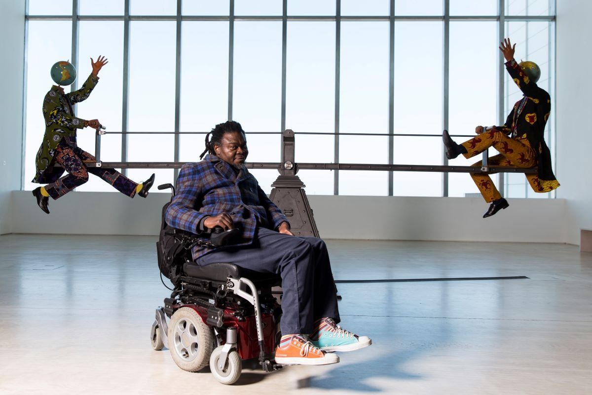 A photo of Yinka Shonibare MBE with his work “End of Empire” at Turner Contemporary as part of the 14-18 NOW programme.