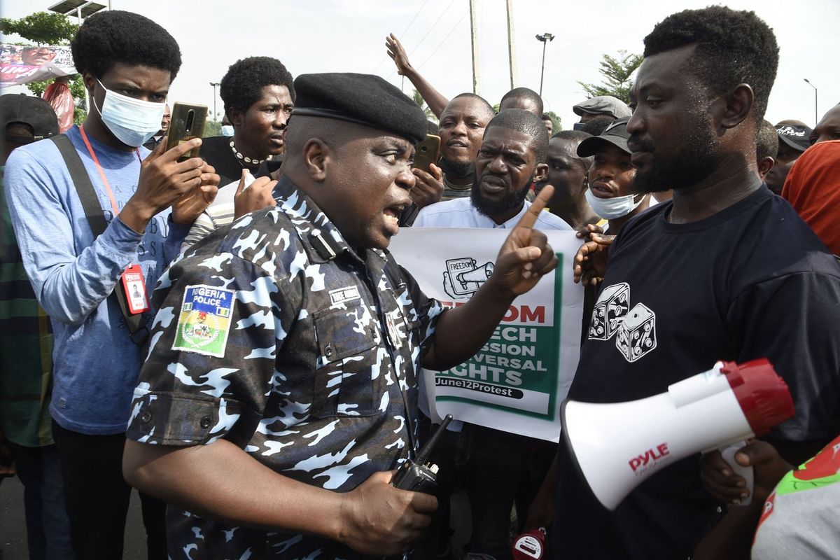 A police officer talks to a protester during a demonstration in Lagos, against bad governance, insecurity, and the ban of social media platform X (then known as Twitter) by the Nigerian presidency, on June 12, 2021. 