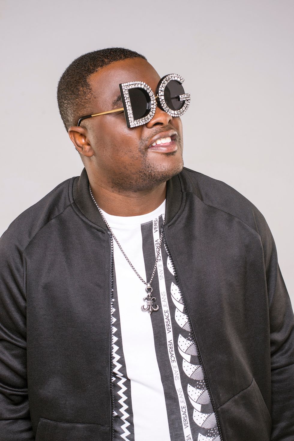 A portrait of DJ Sumbody rocking Dolce & Gabbana shades. 