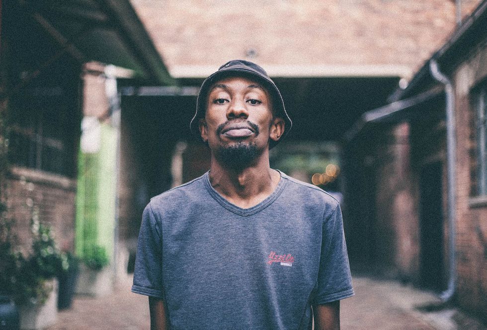 A portrait of Speeka wearing a grey T-shirt and black beanie hat. 