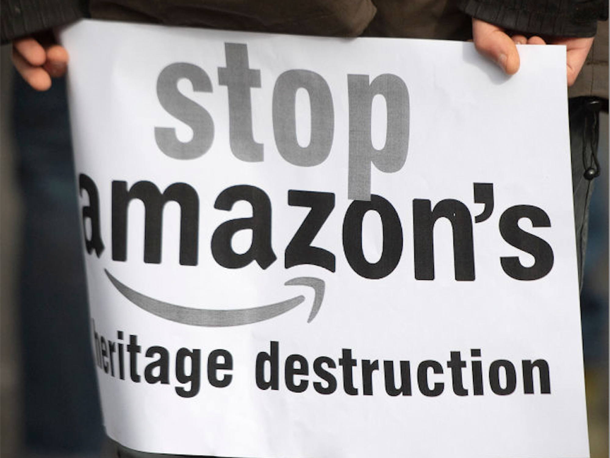 A protestor holds a sign during a rally to halt Amazon's African HQ developments 