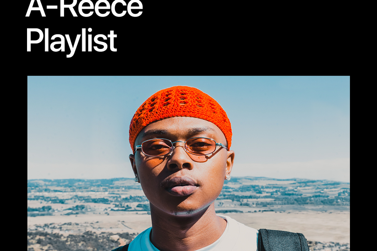 A-Reece sunkissed, wearing an orange woolen hat, glasses and a white t-shirt. 
