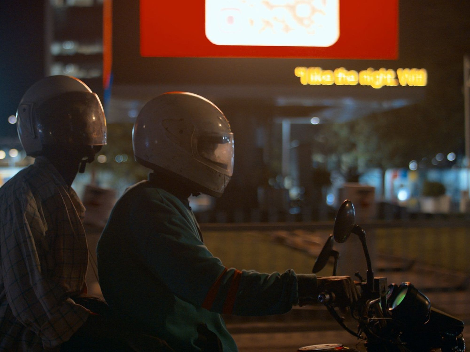 A still from the film of two men on a motorcycle wearing helmets