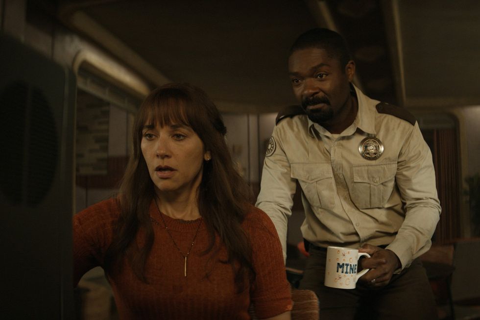 A still from the series of actors Rashida Jones and David Oyelowo looking intently at a TV screen.