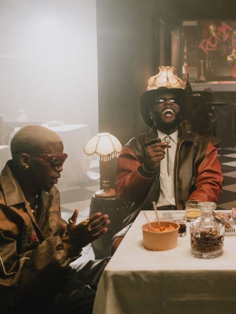 A still from the ‘Tshwala Bam (Remix)’ video, showing Burna Boy, TitoM, Yuppe and S.N.E sitting on a dinner table.
