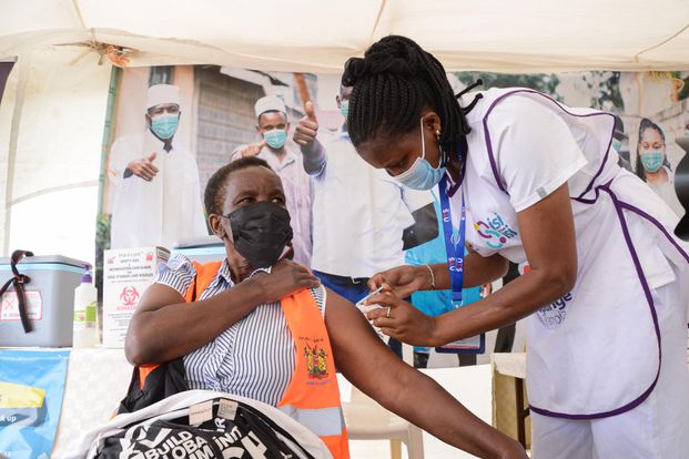 A stock photo of a woman being given an injection by a healthcare worker.