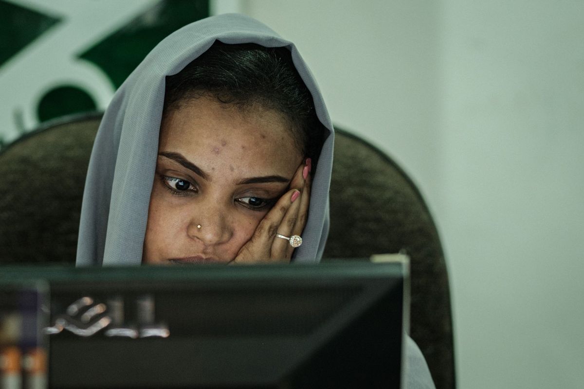 A Sudanese woman works at a travel agency in Khartoum on June 17, 2019 as businesses struggle to keep their services going after being hit by an internet blackout.