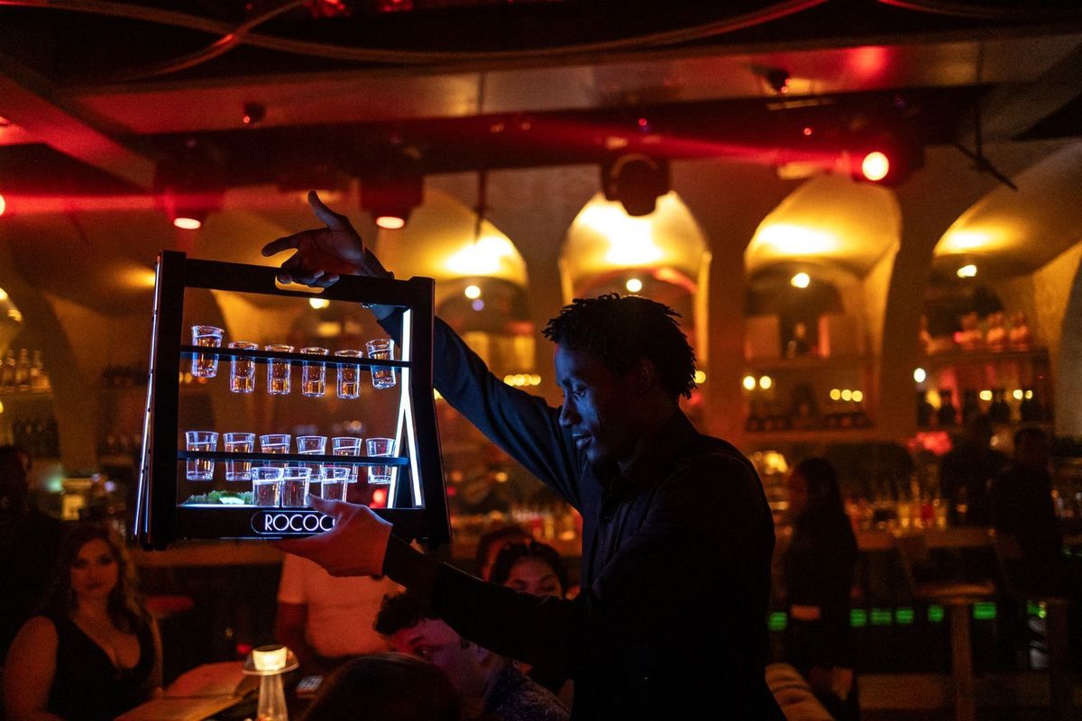 A waiter brings drinks to customers at a restaurant lounge club in Lagos.