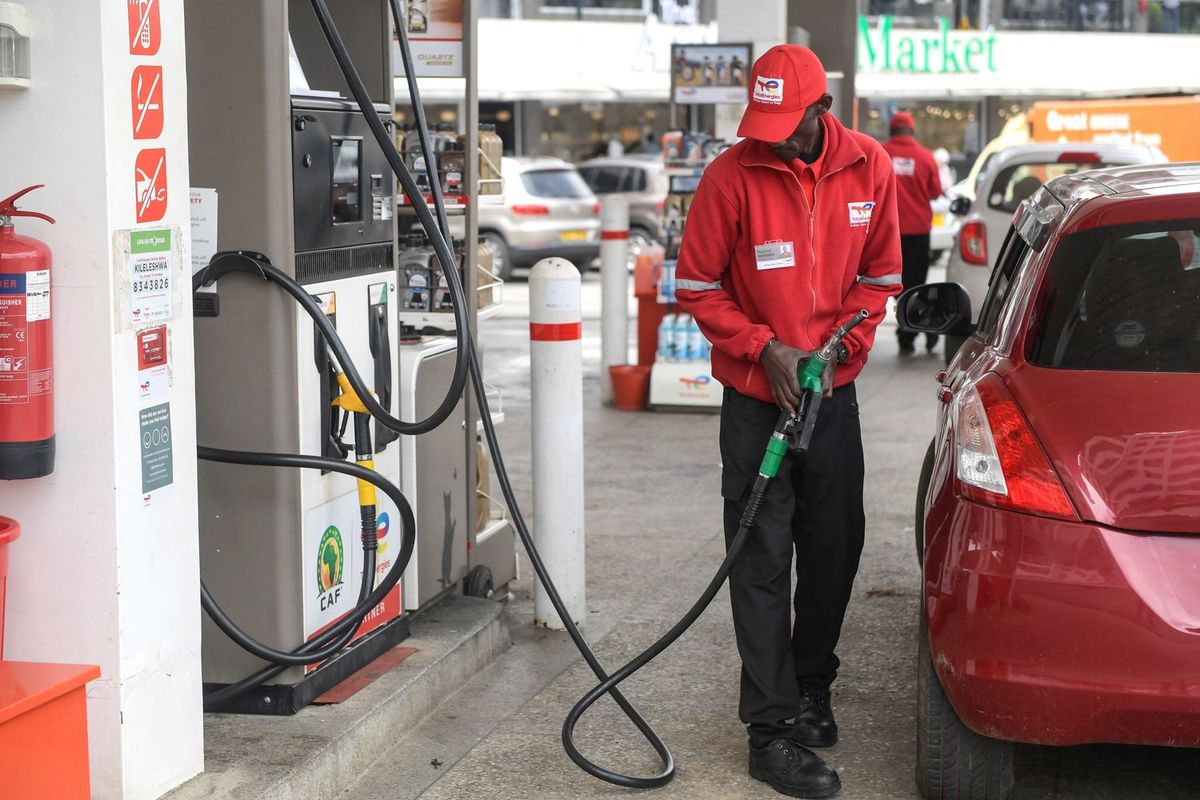 A worker fills the tank of a vehicle at a petrol station as Kenya's government announced a new increase in fuel prices in Nairobi on May 17, 2023. 