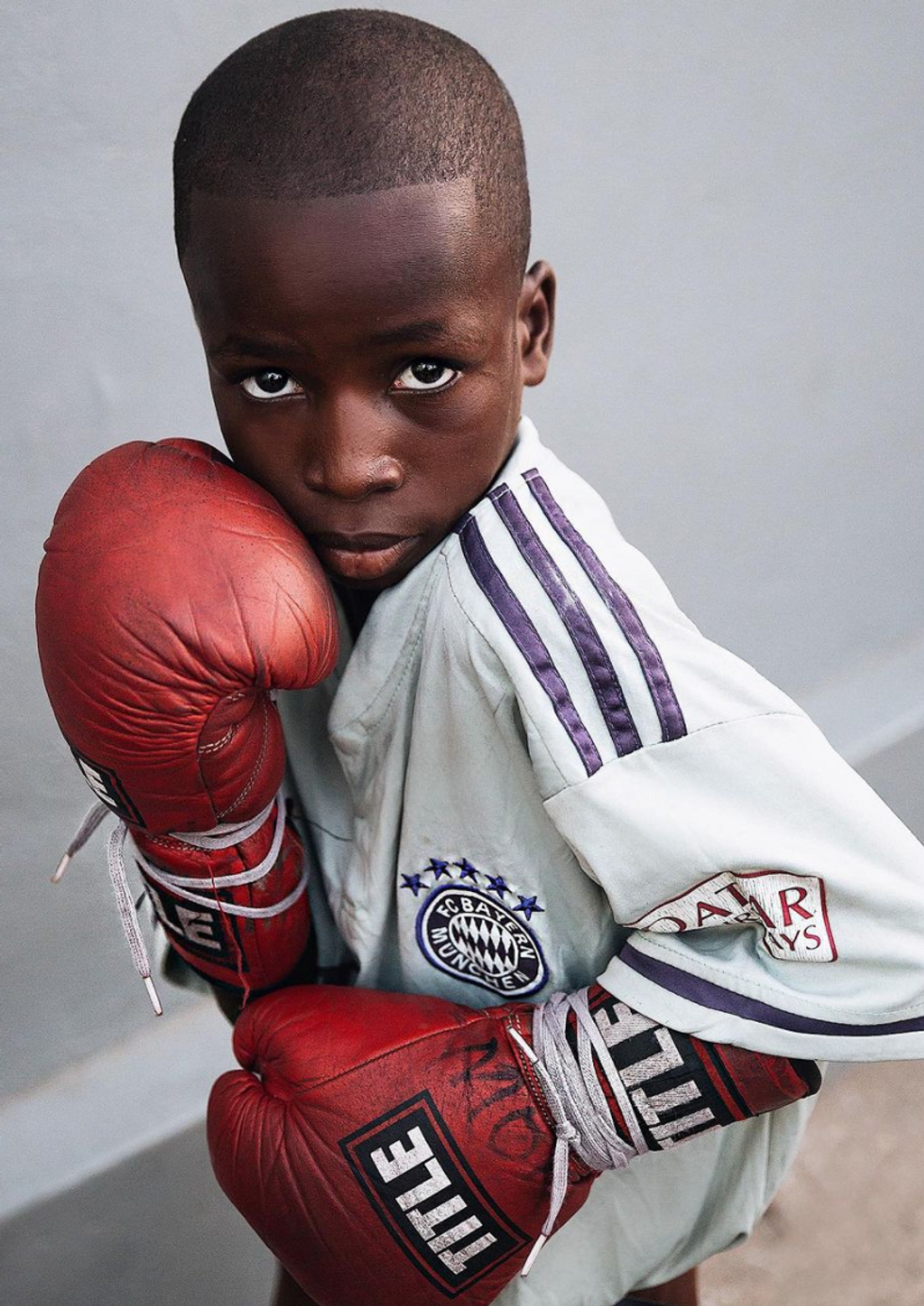 A young boy in boxing gloves
