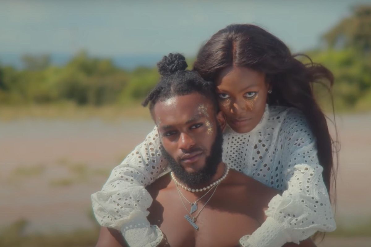 A young couple hold each other in a field in a still scene from Sarkodie's new music video.