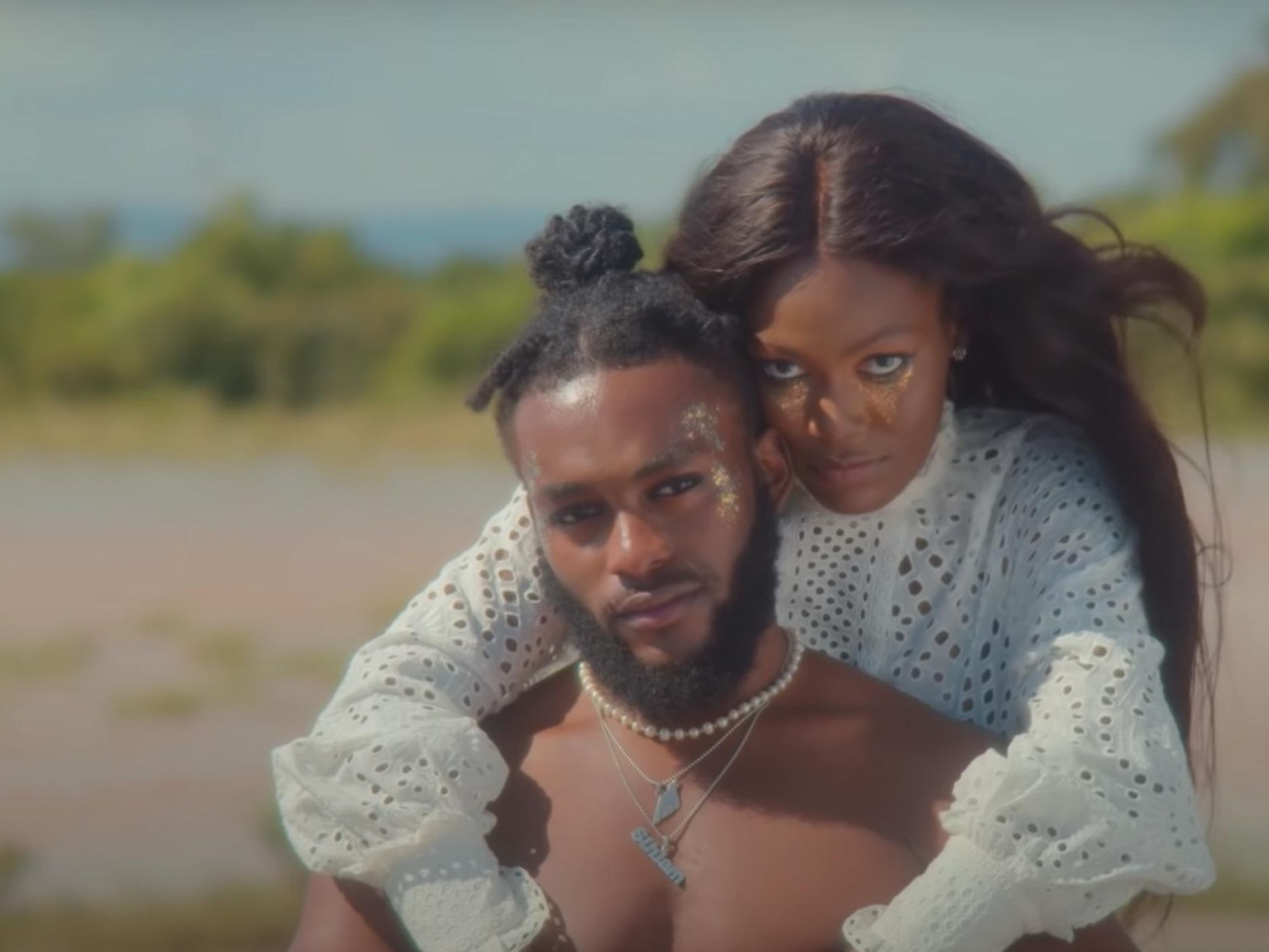 A young couple hold each other in a field in a still scene from Sarkodie's new music video.