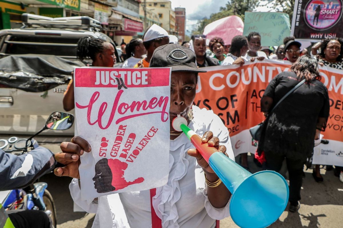 Activists hold up banners and placards in protest of gender-based violence