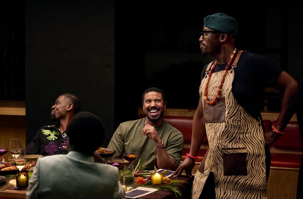 An image from the commercial of Chef Eros standing next to two men seated, one of whom is Michael B. Jordan.