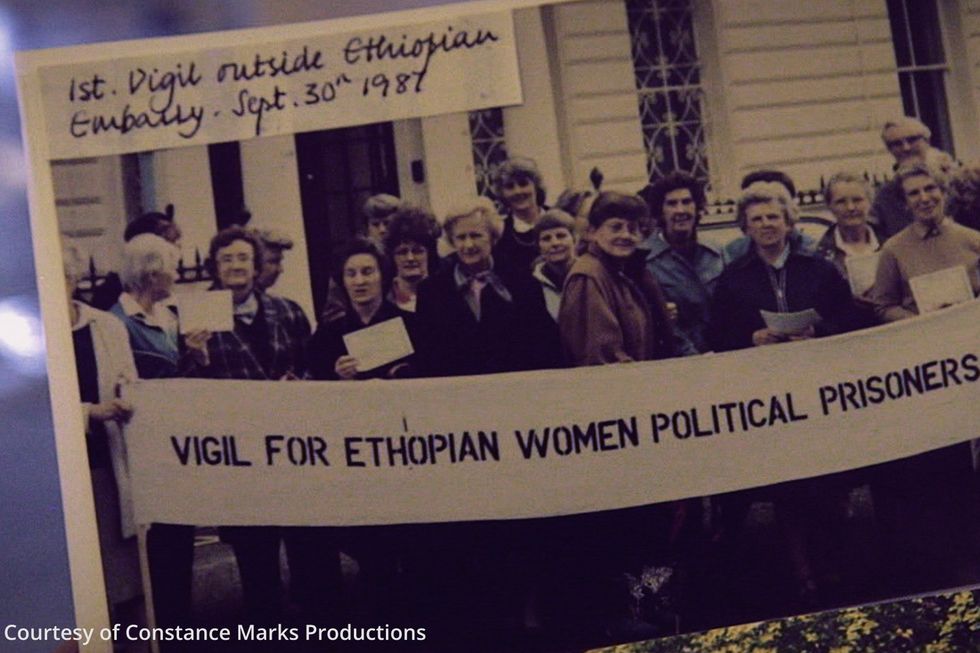 An image from the documentary of a photo of women standing and holding a Vigil for Ethiopian Women Political Prisoners sign.