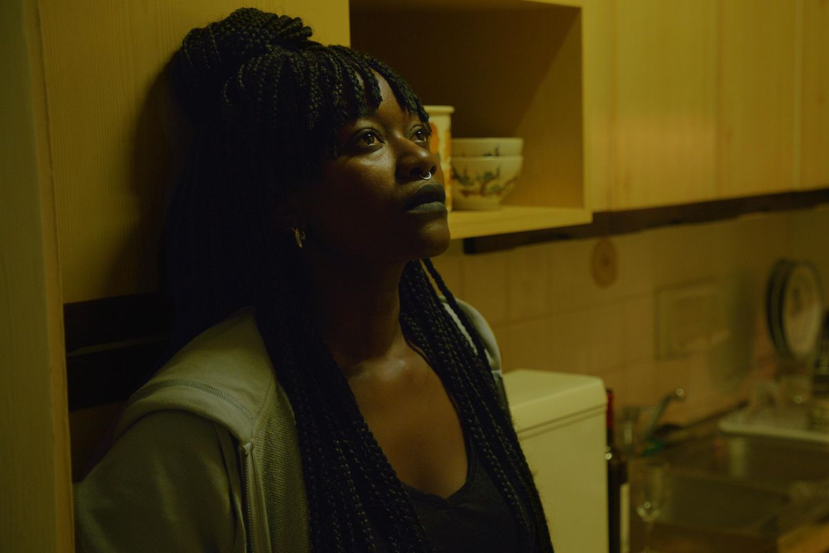 An image from the film of the lead actress leaning against a cupboard