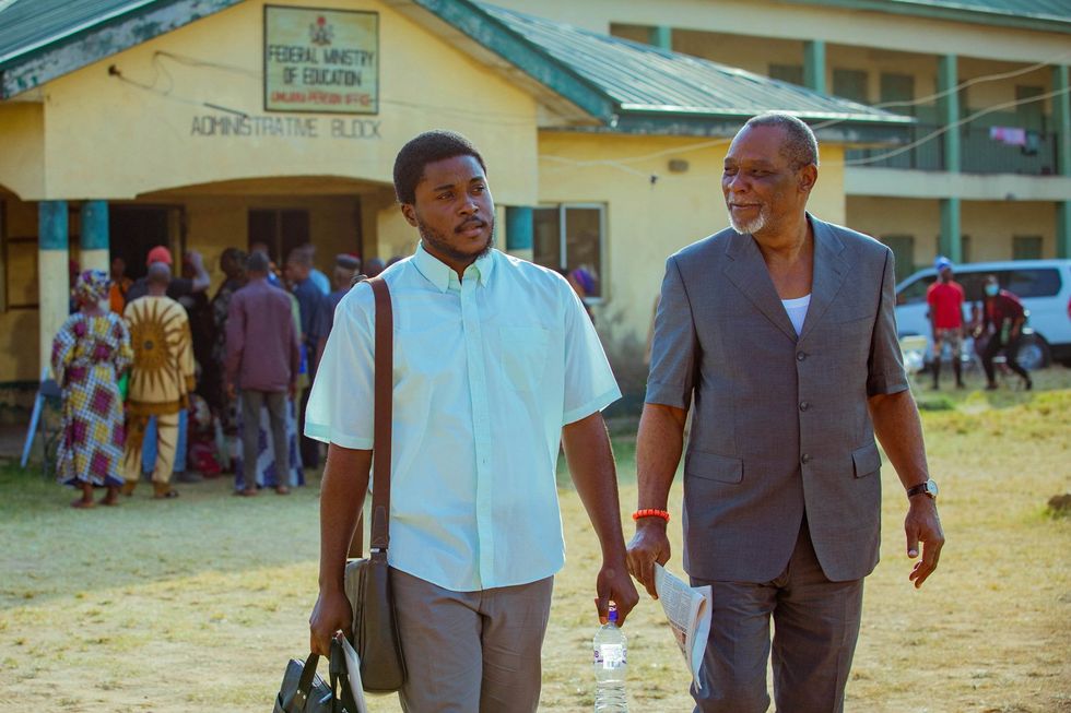 An image from the film of two men walking in the dusty street.