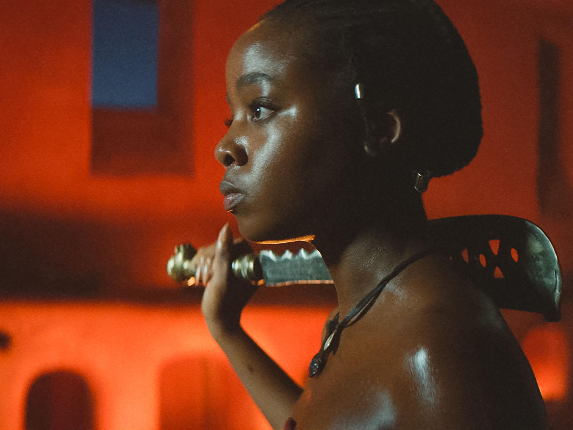 An image from the film The Woman King of Thuso Mbedu holding a machete on her shoulder