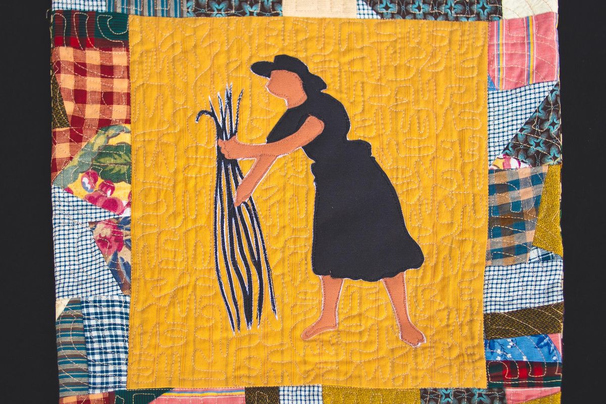 An image of a quilt patch with a woman standing in a rice patch