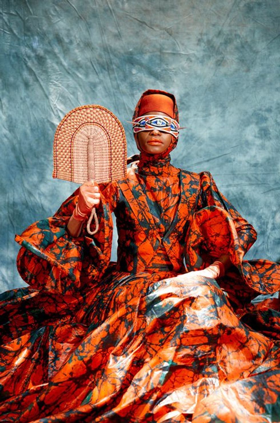 An image of a woman in an orange and green traditional attire ensemble.
